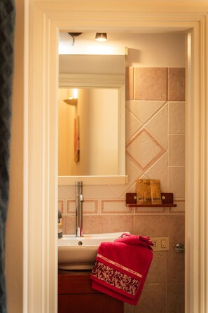 Ein Badezimmer mit Waschbecken, Spiegel und Handtuchhalter.