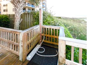 Guests can enjoy a scenic view from this deck, overlooking lush green surroundings.