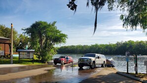 A wet parking area with a white pickup truck and a red boat. - River house with 2 boat docks (Astor)