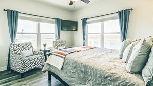 A bedroom with a bed, a chair, a TV, and a ceiling fan. - 100K remodel Jan 2024 - Waterfront Bay/Beach House w/ boat parking private canal (Freeport)