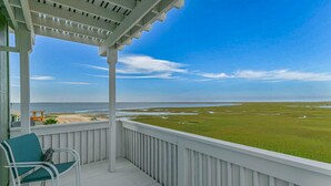 A covered porch with a view of a beach and marshland. - 100K remodel Jan 2024 - Waterfront Bay/Beach House w/ boat parking private canal (Freeport)