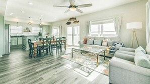 A spacious living area with a dining table, sofa, and a ceiling fan. - 100K remodel Jan 2024 - Waterfront Bay/Beach House w/ boat parking private canal (Freeport)