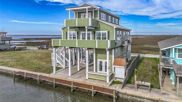 A multi-story house with a balcony, located near a body of water. - 100K remodel Jan 2024 - Waterfront Bay/Beach House w/ boat parking private canal (Freeport)