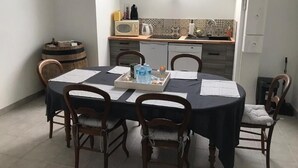 Een eethoek met een ronde tafel, vier stoelen en een dienblad met waterflessen.