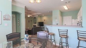 Enjoy social gatherings in this inviting space with a kitchen, dining area, and comfortable seating options.