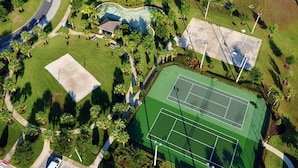 An aerial view of a sports complex with multiple tennis courts, a swimming pool, and surrounding greenery. - Welcome to The Windsor Fantasy with Brand New Professional Arcade Room! (Kissimmee)