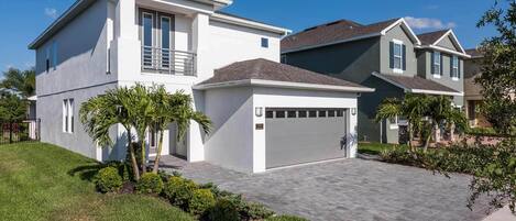 A modern two-story house with a garage, a well-maintained lawn, and a driveway.
