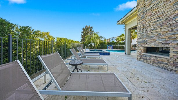 Zona junto a la piscina con sillones de descanso y piscina.