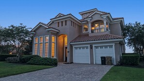 A two-story house with a driveway, garage, and well-maintained lawn.