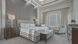 Une chambre moderne avec un grand lit, des tables de chevet, une chaise et une commode.