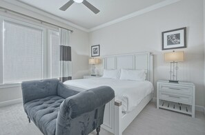 A bedroom with a bed, a chair, bedside tables, and a ceiling fan. - Sun-Filled Haven with Sports Themed Game Room at Reunion (Reunion)