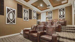 Une salle de cinéma maison avec des fauteuils inclinables en cuir marron, une moquette à motifs et des panneaux muraux décoratifs.