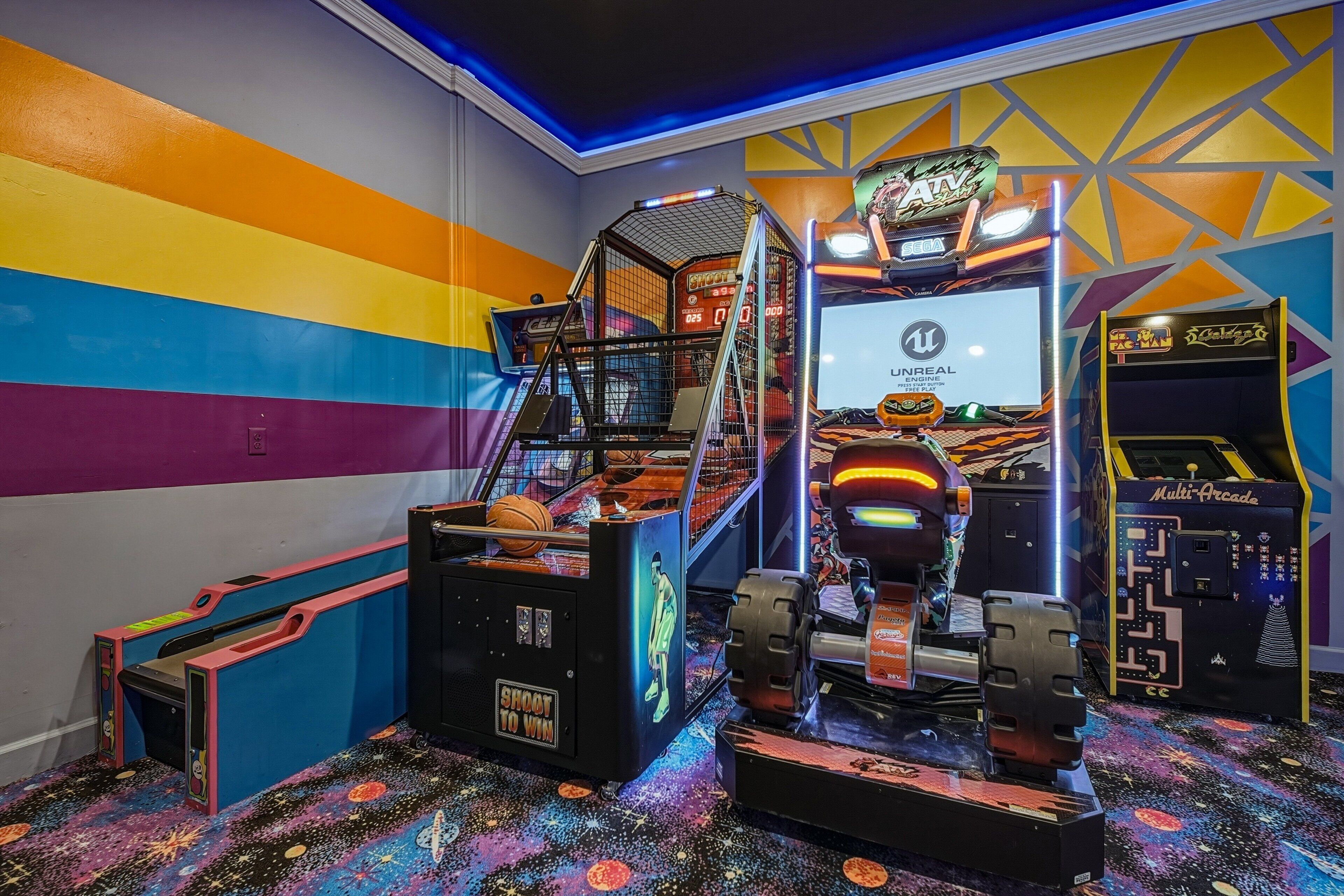 Un salón de juegos vibrante con diversas máquinas, incluyendo un juego de baloncesto y un juego de carreras.