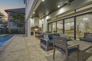 Un espace de vie extérieur moderne comprenant une piscine, une table à manger et un canapé.