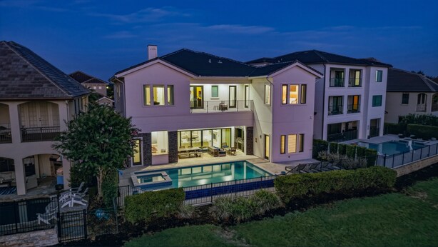 Une maison à deux étages avec une piscine, un balcon et un jardin bien entretenu.