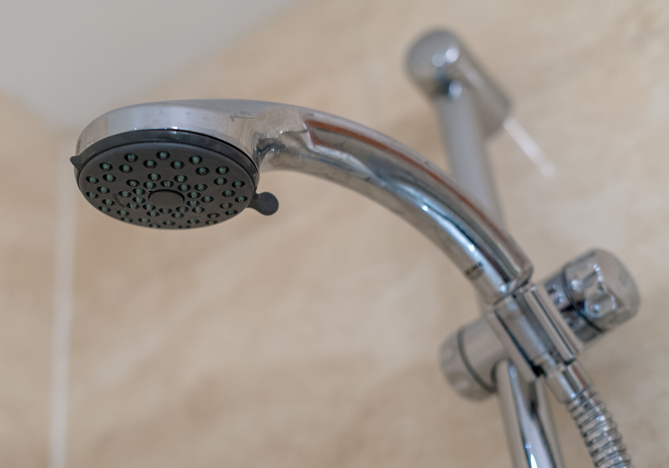 A showerhead with a curved design and a visible water flow.