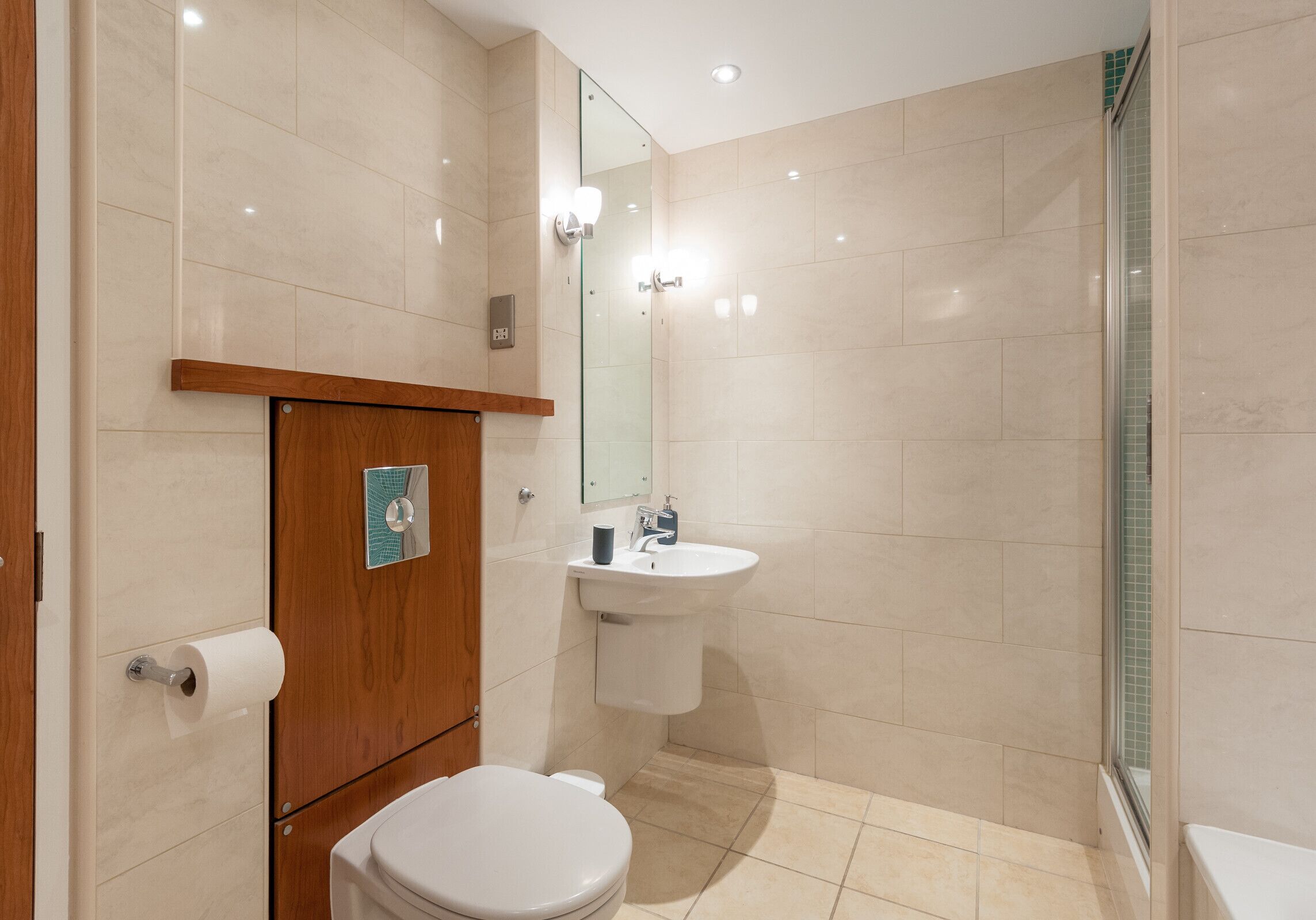 Une salle de bain équipée de toilettes, d’un lavabo et d’une douche.