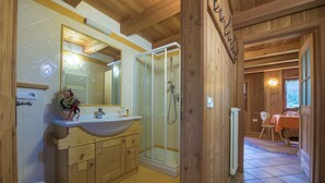 A wooden cabin bathroom with a sink, mirror, and shower. - MAS DE LA BOLP,  MOUNTAIN CHALET (Rabbi)