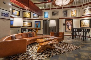 A lounge area with a curved leather sofa, a wooden coffee table, and a checkered rug. - Charlie's Slopeside: Best Location BC Village! Creekside Unit, Walk to Lifts, Ski School, Dining (Beaver Creek)