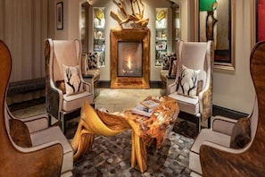 A lounge area with two armchairs, a central coffee table, and a fireplace. - Charlie Rentz: Best Location BC Village! Creekside Unit, Walk to Lifts, Ski School, Dining (Beaver Creek)