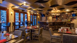 A restaurant with a modern interior, featuring a unique ceiling design, a bar area, and large windows with a view of the outdoors. - Charlie's Slopeside: Best Location BC Village! Creekside Unit, Walk to Lifts, Ski School, Dining (Beaver Creek)