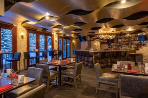 A restaurant with a modern interior, featuring a unique ceiling design, a bar area, and large windows with a view of the outdoors. - Charlie's Slopeside: Best Location BC Village! Creekside Unit, Walk to Lifts, Ski School, Dining (Beaver Creek)