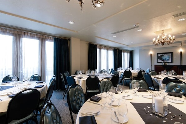 A hotel dining room with round tables, black upholstered chairs, and chandeliers. - Charlie Rentz: Best Location BC Village! Creekside Unit, Walk to Lifts, Ski School, Dining (Beaver Creek)