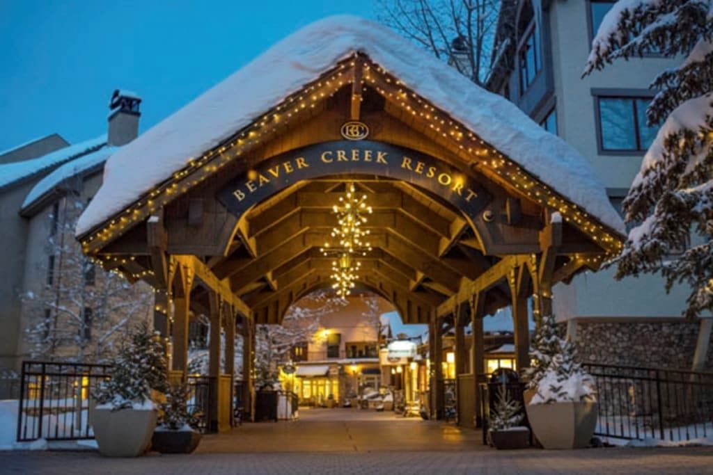 The entrance to Beaver Creek Resort with a covered walkway and snow-covered trees.
