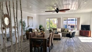 Un salón amplio con una mesa de comedor, sofás y un televisor.