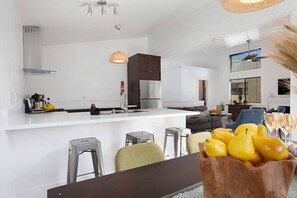 A modern kitchen with a central island, bar stools, and a dining table. - Fabulous Townhouse, close to beach, town and harbor (Dana Point)