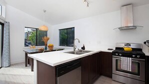 A modern kitchen with a central island, stainless steel appliances, and a large window providing natural light. - Fabulous Townhouse, close to beach, town and harbor (Dana Point)