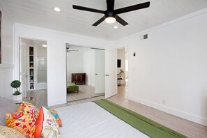 A spacious room with a ceiling fan, a bed with colorful pillows, and a green rug. - Fabulous Townhouse, close to beach, town and harbor (Dana Point)
