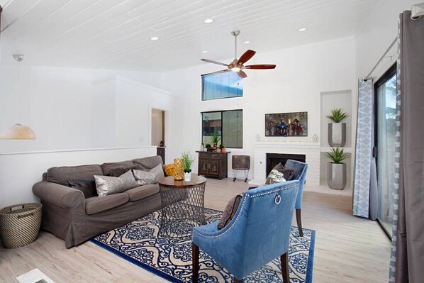 A modern living room with a sofa, armchair, coffee table, and patterned rug. - Fabulous Townhouse, close to beach, town and harbor (Dana Point)