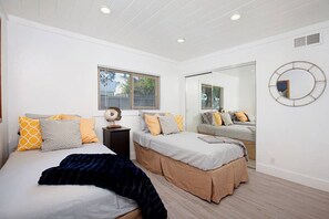 A bedroom with two beds, a large mirror, and a window with blinds. - Fabulous Townhouse, close to beach, town and harbor (Dana Point)