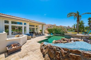 A poolside area with a fire pit, outdoor seating, and a view of the pool. - Waterslide, heated pool home, PGA West 6th tee box (La Quinta)