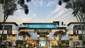 A modern building with a large entrance, outdoor seating area, and a water feature. - Cacao Tulum -Luxury Condos- (Tulum)