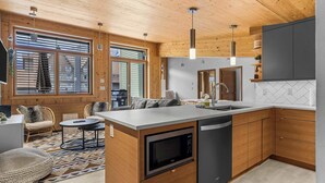 Una cocina moderna con armarios de madera, microondas integrado y lavavajillas.