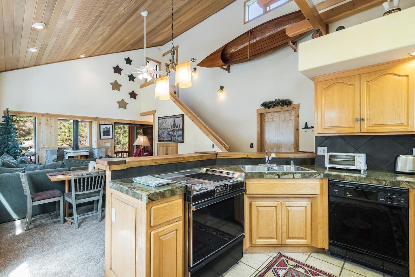 A modern kitchen with wooden cabinets, a built-in oven, and a dining area with a table and chairs.