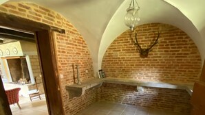 Une pièce avec un mur en briques, une cheminée et un sol carrelé.