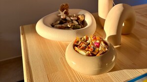 A wooden table with decorative bowls containing dried flowers and seashells, and a vase with dried flowers. - Cennet Hotel (Fethiye)