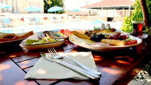 A dining table with plates of food, a fork, and a napkin. - Cennet Hotel (Fethiye)