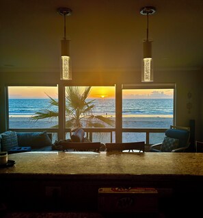 A room with a view of the ocean at sunset, a bar area, and a dining table. - BEST ON THE BEACH!!⛱ Oceanfront Stunning 2 1/2 Bdrm 2Ba,  2 Garage, 8 bed spaces (San Diego)