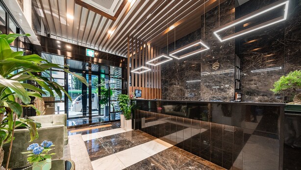 A modern lobby with a marble floor, wooden paneling, and a reception desk. - Hotel RU136 (Seoul)