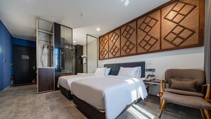 A modern hotel room with a large bed, a seating area, and a bathroom with a glass shower enclosure. - Hotel RU136 (Seoul)
