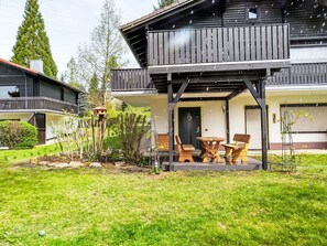 A two-story building with a wooden balcony and outdoor seating area. - Am Hohen Bogen by Interhome (Arrach)