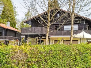 A two-story wooden building with a balcony and a covered patio area. - Am Hohen Bogen by Interhome (Arrach)