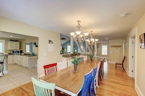A spacious kitchen with a central island, wooden dining table, and chairs. - 26 42nd Avenue (Isle of Palms)
