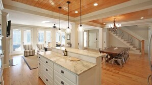 A spacious kitchen with a large island, wooden ceiling, and pendant lights. - 2602 Hartnett Boulevard (Isle of Palms)