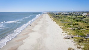 A beach with a pier extending into the ocean, a water tower, and a grassy area with pathways. - 2307 Palm Boulevard (Isle of Palms)