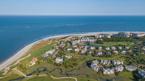 An aerial view of a coastal residential area with houses, a beach, and a marina. - 21 Ocean Point (Isle of Palms)